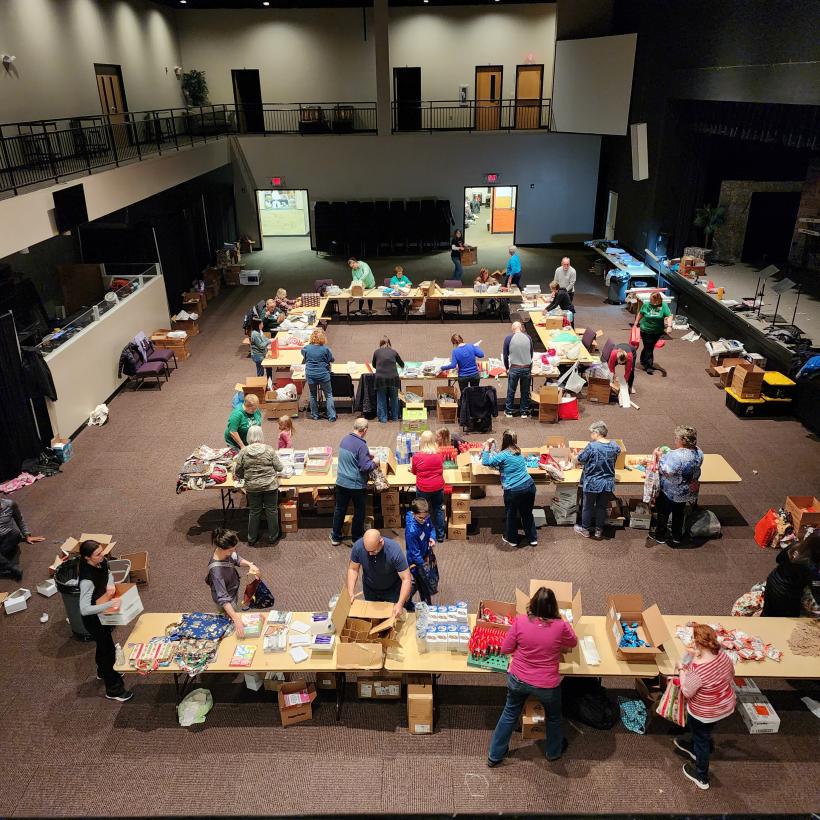 Volunteers gather to wrap gifts and stuff stockings